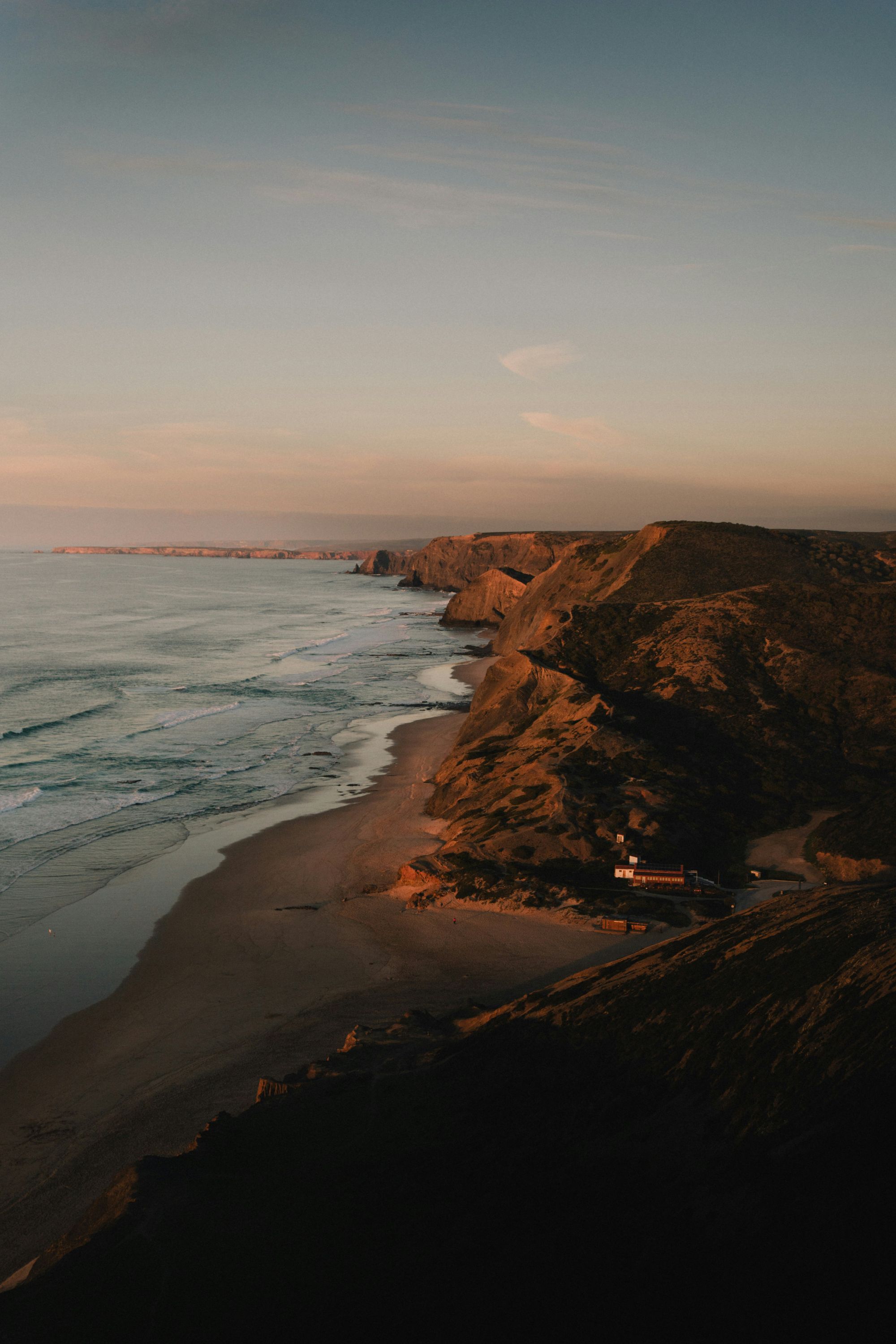 A warm golden-hour coastline with cliffs meeting the sea